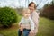 Grandmother with her toddler grandson having fun outdoors on beautiful spring day. Grandma taking a walk with her grandchild