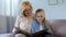 Grandmother hugging granddaughter and showing her young pictures, memories