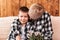 Grandmother hugs her grandson sitting on the couch