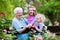 Grandmother and kids sitting in rose garden