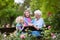 Grandmother and kids sitting in rose garden