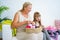 Grandmother knitting with granddaughter