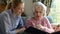 Grandmother Looking At Photo Album With Adult Granddaughter