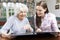 Grandmother Looking At Photo Album With Teenage Granddaughter