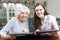 Grandmother Looking At Photo Album With Teenage Granddaughter