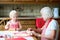 Grandmother making cookies together with granddaughter