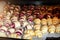 Grandmother making handmade tasty butter rolling cookies with fruit and berry jam on oven tray before baking at kitchen