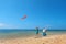 Grandmother, mother, and child launching kite on sea beach