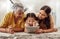 Grandmother, mother and child with a tablet streaming a movie while relaxing together. Shocked, surprised and happy