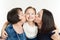 The grandmother and mother kiss the granddaughter