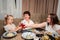 grandmother, mother and little daughter sit at tables of cafes and drink juice