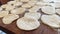 grandmother prepares delicious dumplings or pies or dumplings for her grandson she shakes dough, cuts it into pieces and