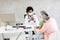 Grandmother with protective facial masks with granddaughter at black female doctor