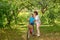 A grandmother  rides on a big red bike of a grandson  in a garden or in a forest on a sunny summer day