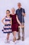 Grandmother sits on a swing, and granddaughter and grandfather are standing nearby, photo on a gray background