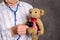 Grandmother with stethoscope is puppet doctor for teddy bear