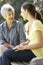 Grandmother Talking With Teenage Granddaughter On Bench