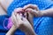 Grandmother teaches her granddaughter to knit. Hands of old woman and young girl. Shallow DOF.