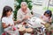 Grandmother teaching her granddaughters how to make christmas Nativity crafts