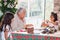 Grandmother teaching her granddaughters how to make christmas Nativity crafts