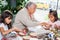 Grandmother teaching her granddaughters how to make christmas Nativity crafts