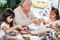 Grandmother teaching her granddaughters how to make christmas Nativity crafts