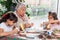 Grandmother teaching her granddaughters how to make christmas Nativity crafts