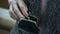 Grandmother trembling hand putting coin in wallet, pensioner poverty, closeup