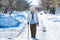 Grandmother walk with cane on road. old person leaning on a walking stick. caucasian female senior at cold winter