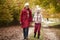 Grandmother Walking Along Autumn Path With Granddaughter