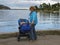 Grandmother walks with her newborn granddaughter along the seashore. Family holidays in a country house with grandparents