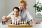 Grandmother and young girl playing chess together at home