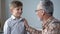 Grandpa giving advice to boy, teaching younger generation, sharing experience