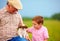 Grandpa and grandson playing with little puppy, summer outdoors