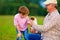 Grandpa and grandson playing with little puppy, summer outdoors