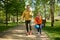 Grandpa with grandson walking in park preparing get ready to roller-skate