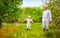 Grandpa with grandson walking through the spring garden