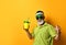 Grandpa in green sun visor, shirt, sunglasses. Holding cocktail bottle in form of pineapple with tube, posing on orange background