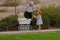 Grandpa helping little girl with hat on walk with toy buggy