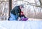 Grandpa helps boy down a sledding hill