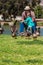 Grandpa helps happy little girl feed ducks at lake