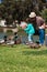 Grandpa helps little girl feed ducks at lake