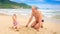 Grandpa Little Blond Girl Sit Draw on Wet Sand of Beach by Surf
