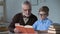 Grandpa reading aloud adventure story to little grandson, family care and warmth