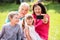 Grandparent And Grandchildren Taking Picture In Park