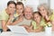 Grandparents with adult daughter and grandchildren using laptop