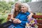 Grandparents Day, Reunited family, togetherness. Senior old grandma hugs granddaughter outdoors. Grandchild makes