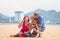 Grandparents enjoying day with granddaughter while blowing soap bubbles on the beach near the sea