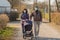 Grandparents in facial masks walking with baby in buggy during quarantine