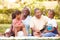 Grandparents And Grandchildren Having Picnic In Garden